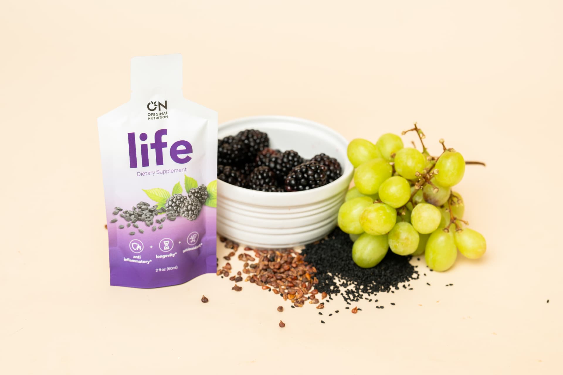 Original Nutrition Life pouch with blackberries, grapes and seeds on a beige surface
