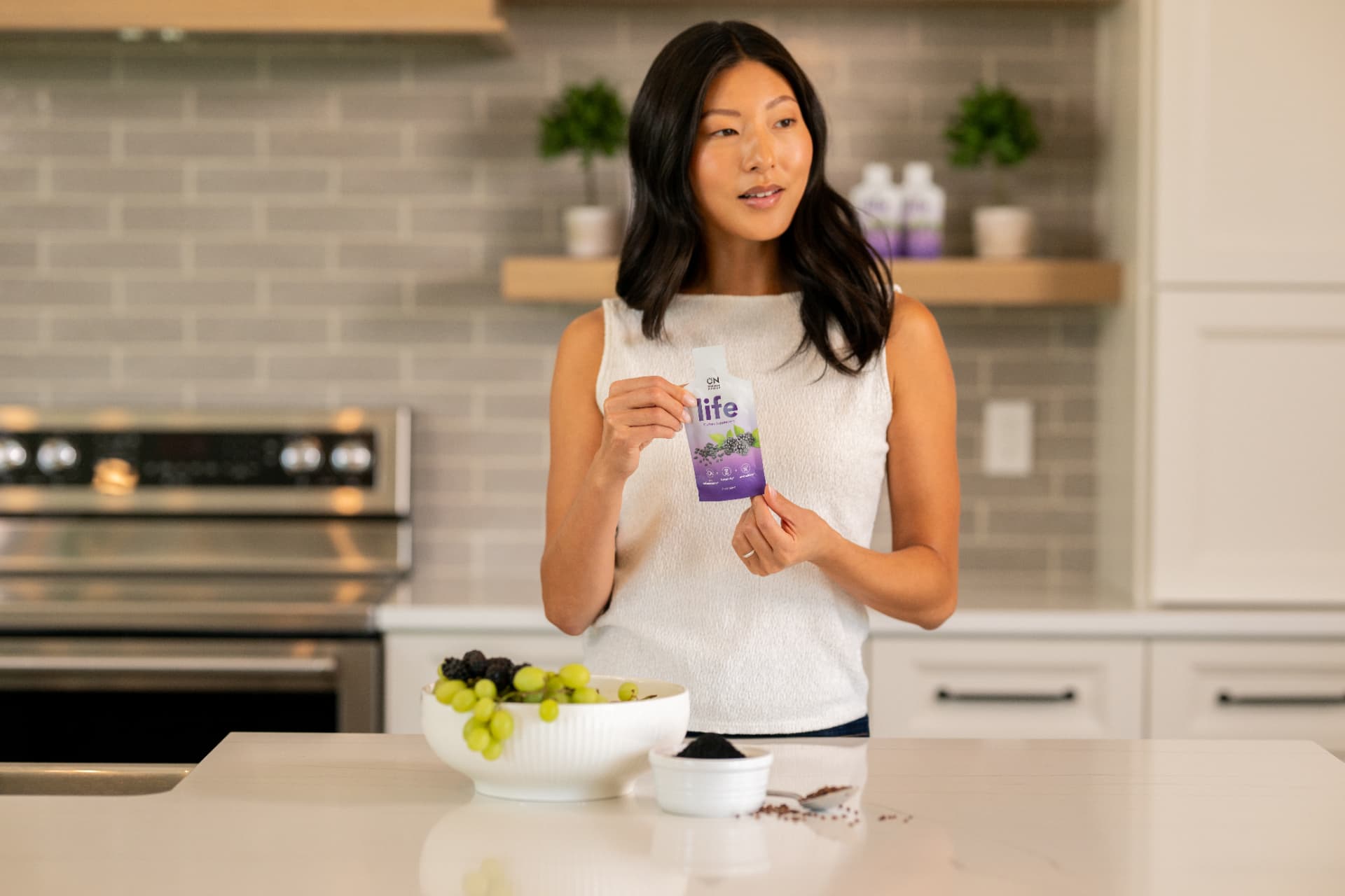 Original Nutrition Life packet held in a modern kitchen with a bowl of fruit